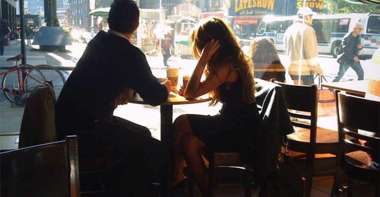 man-and-woman-in-coffee-shop-looking-through-window
